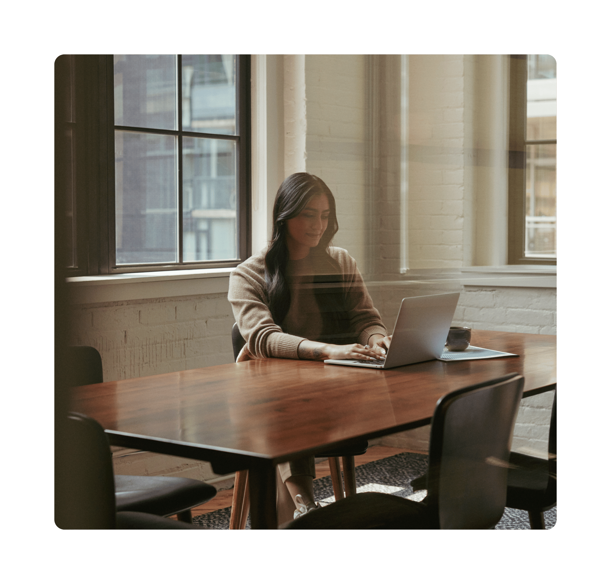 Wealthsimple employee working at a laptop in a meeting room