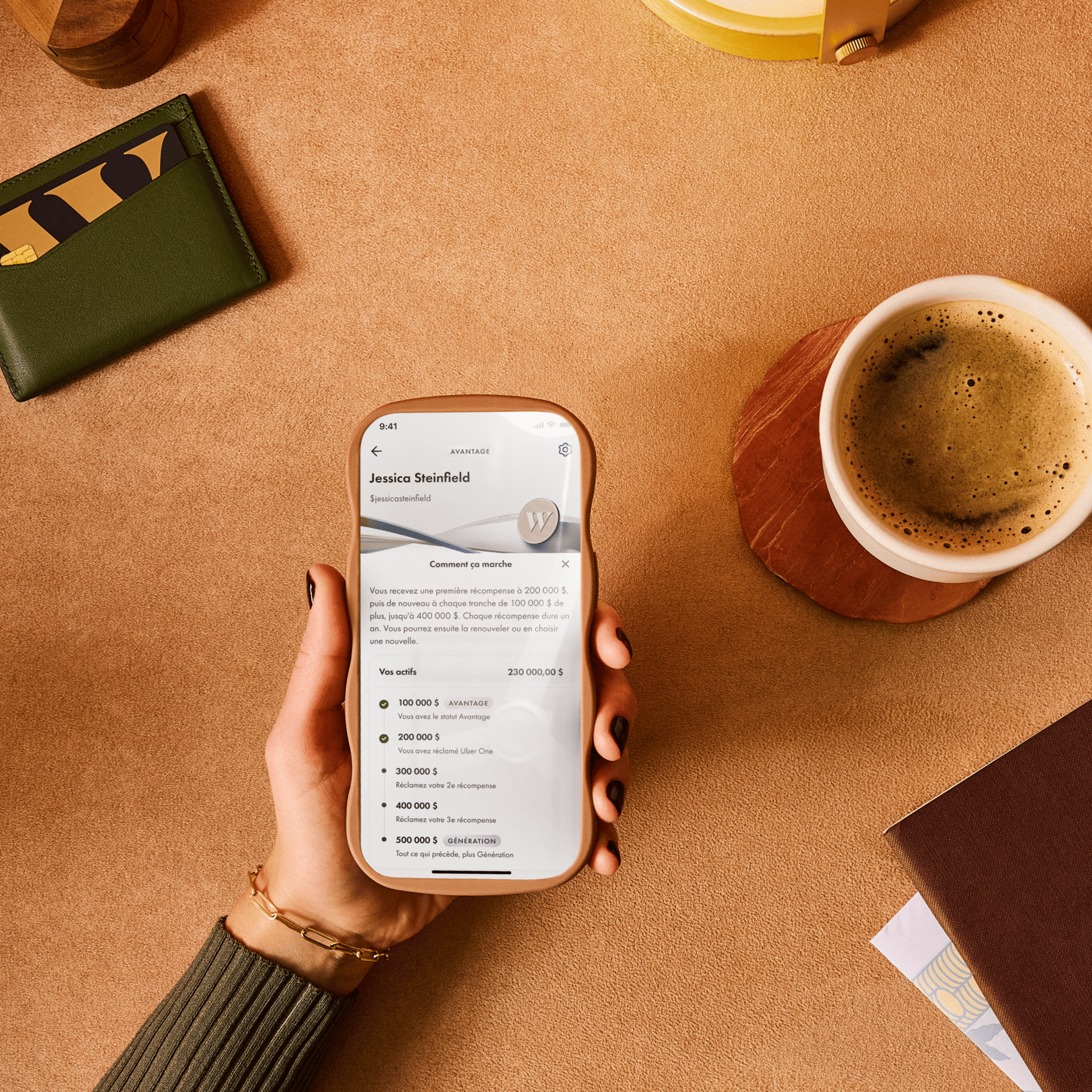 Une main tenant un téléphone et utilisant l'application Wealthsimple