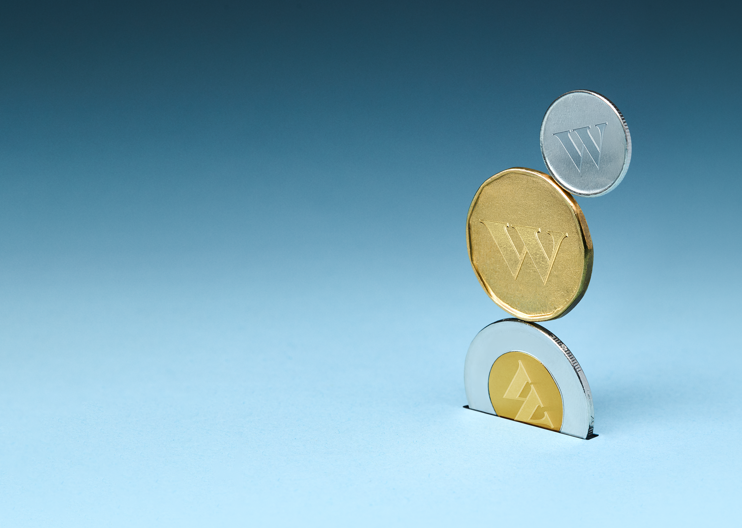Trois pièces de monnaie portant le logo Wealthsimple entrant dans une fente.