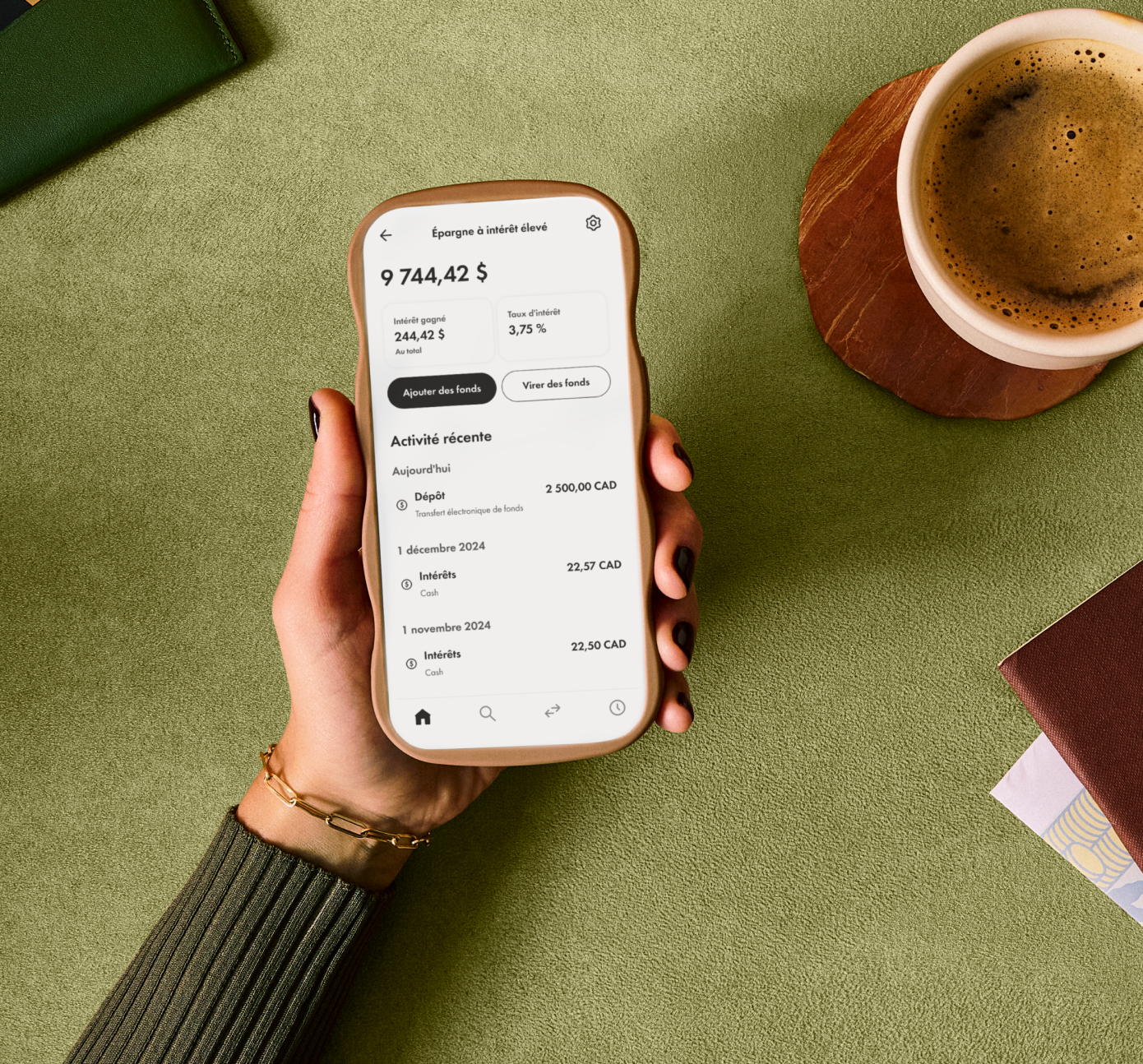 Une personne tenant un téléphone qui affiche l'expérience du compte d’épargne enregistré Wealthismple