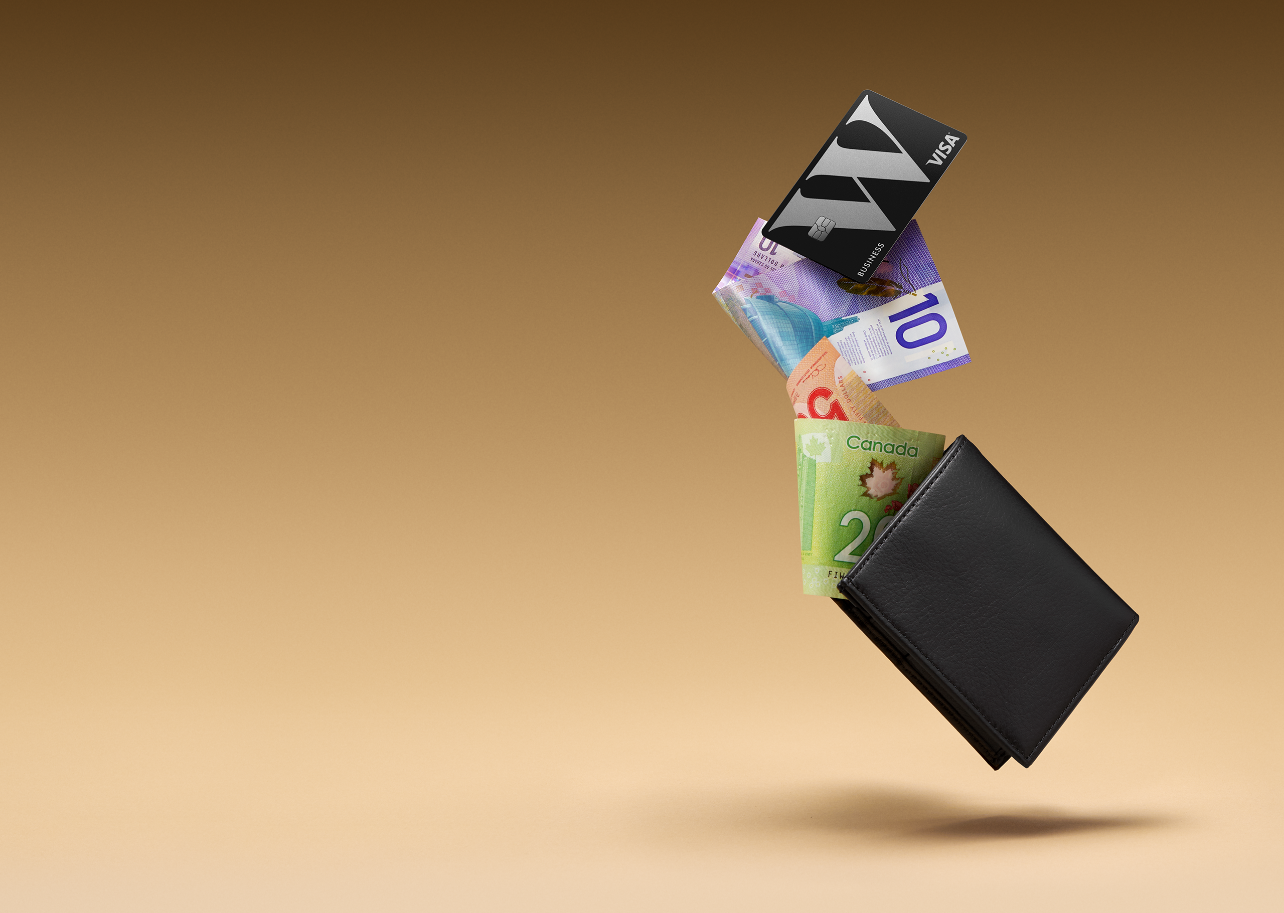 Une carte Wealthsimple Entreprises Visa et des billets d'argent qui s'envolent d'un porteuille.