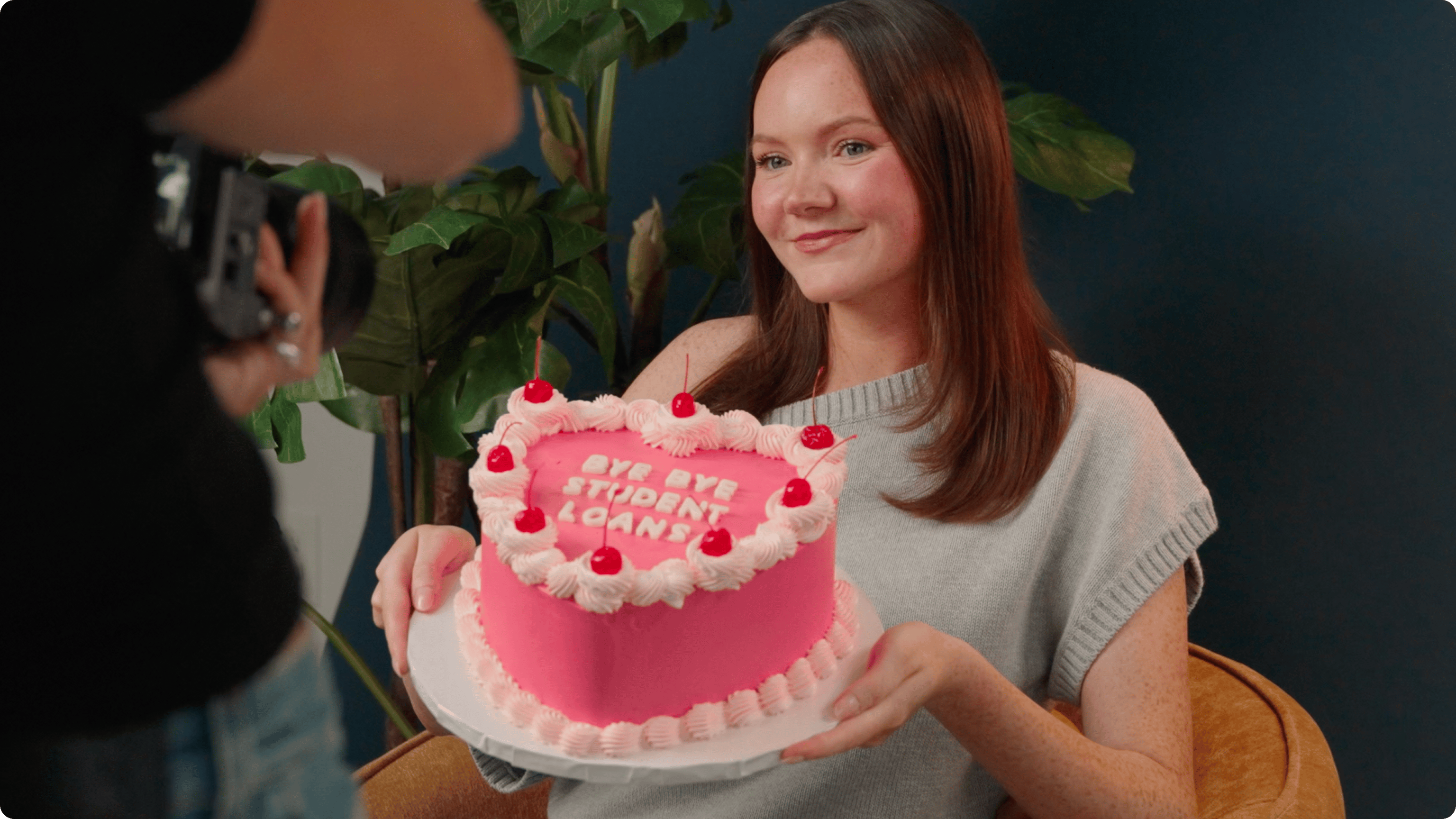 Our million dollar winner Chantelle, holding a cake that says "Bye Bye Student Loans"