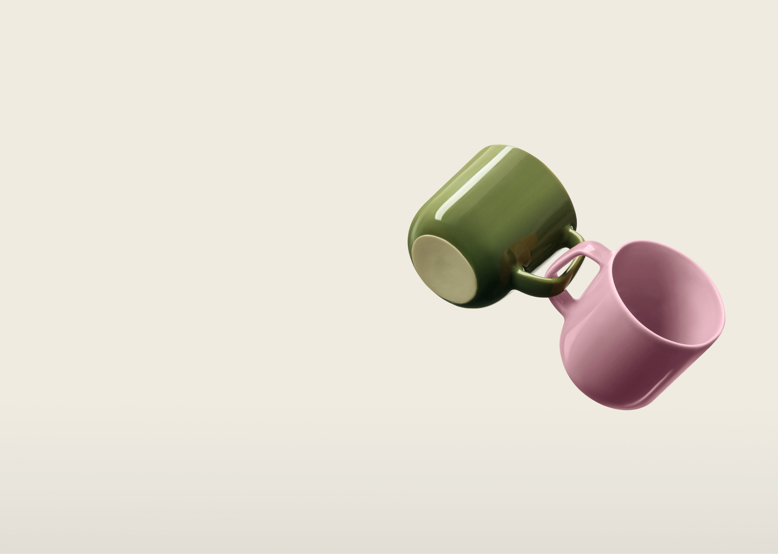 Une tasse verte et une tasse rose, reliées par leurs anses.