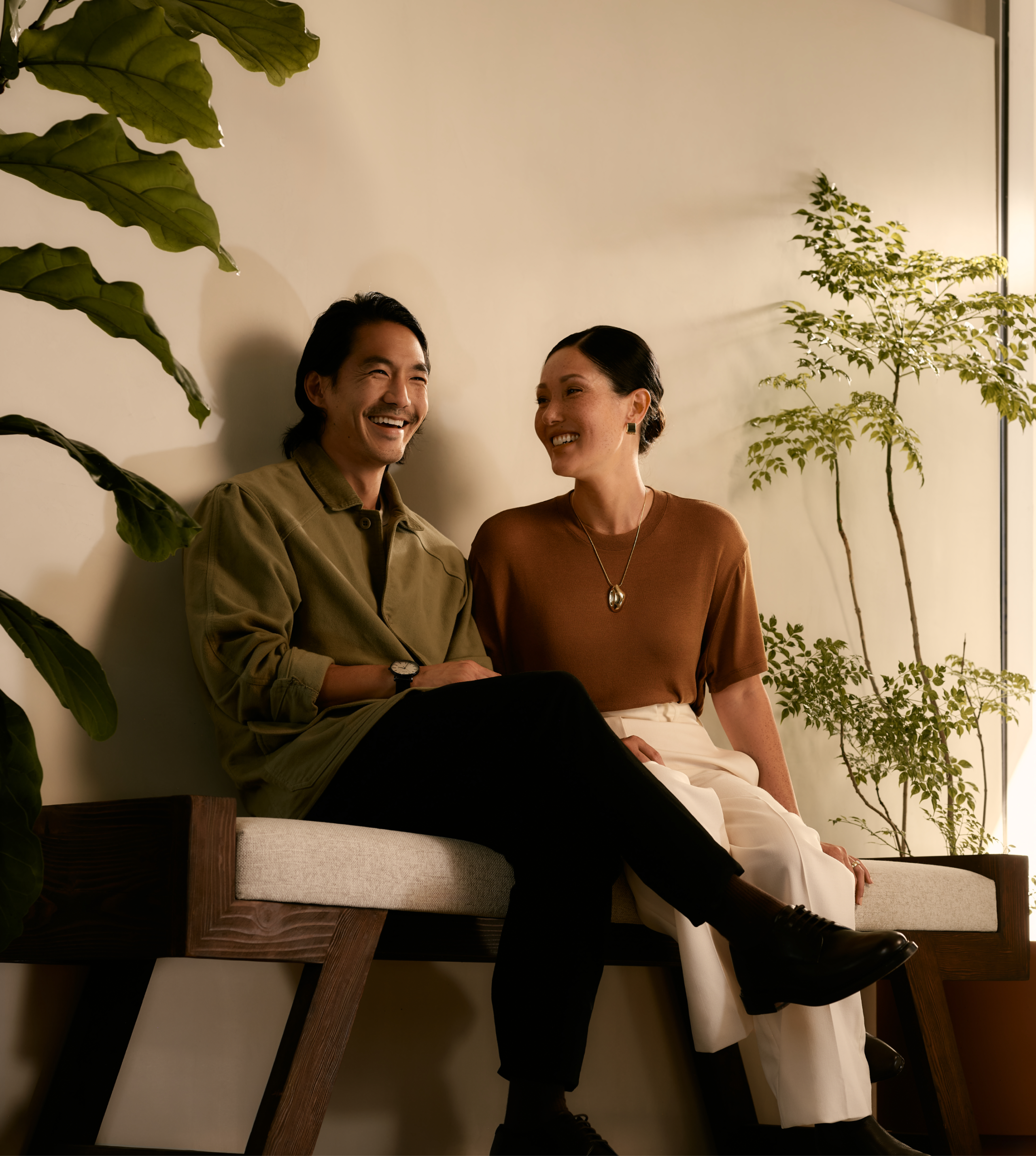 A smiling couple sitting on a bench 